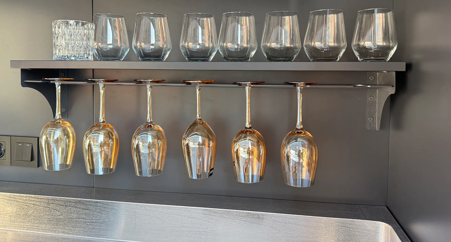 Détail étagère à verres intégrée sous meuble haut avec verres suspendus — rangement intelligent Pod BarbecueZone