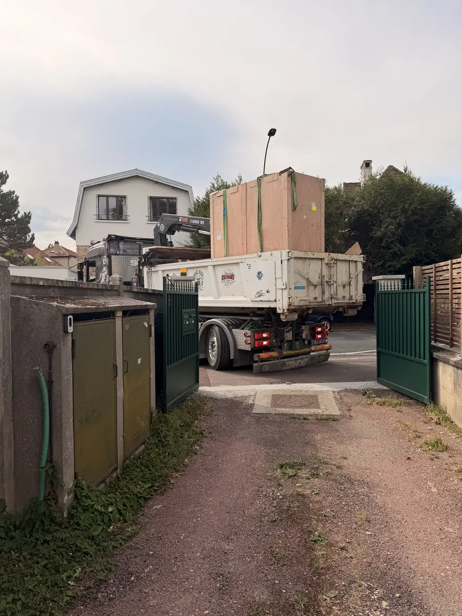 Livraison d'une cuisine d'été couverte BarbecueZone à Saint-Germain-en-Laye — camion-grue dans la rue, Pod sanglé dans sa caisse de transport devant le portail