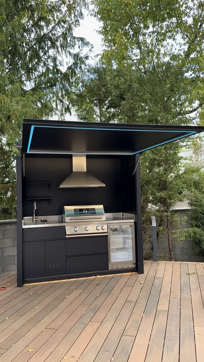 Vue de face de la cuisine d'été couverte BarbecueZone ouverte — structure inox 304, plan de travail inox, hotte intégrée et éclairage LED sous le toit